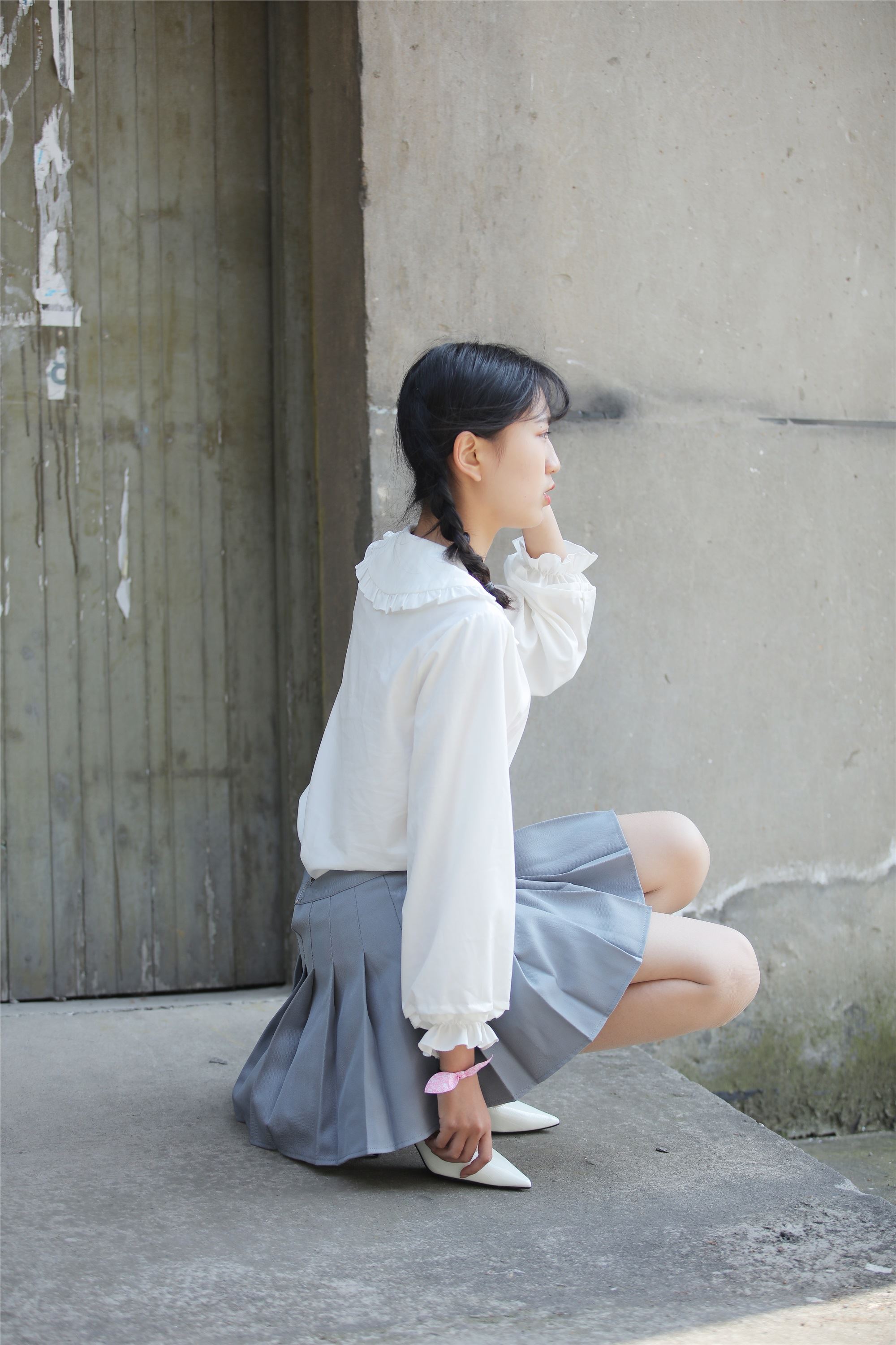 Little Orange with ponytail and white pleated skirt